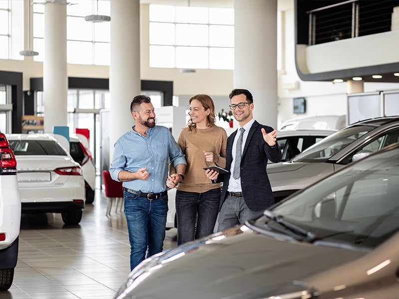 A sales person talking to a couple in a showroom